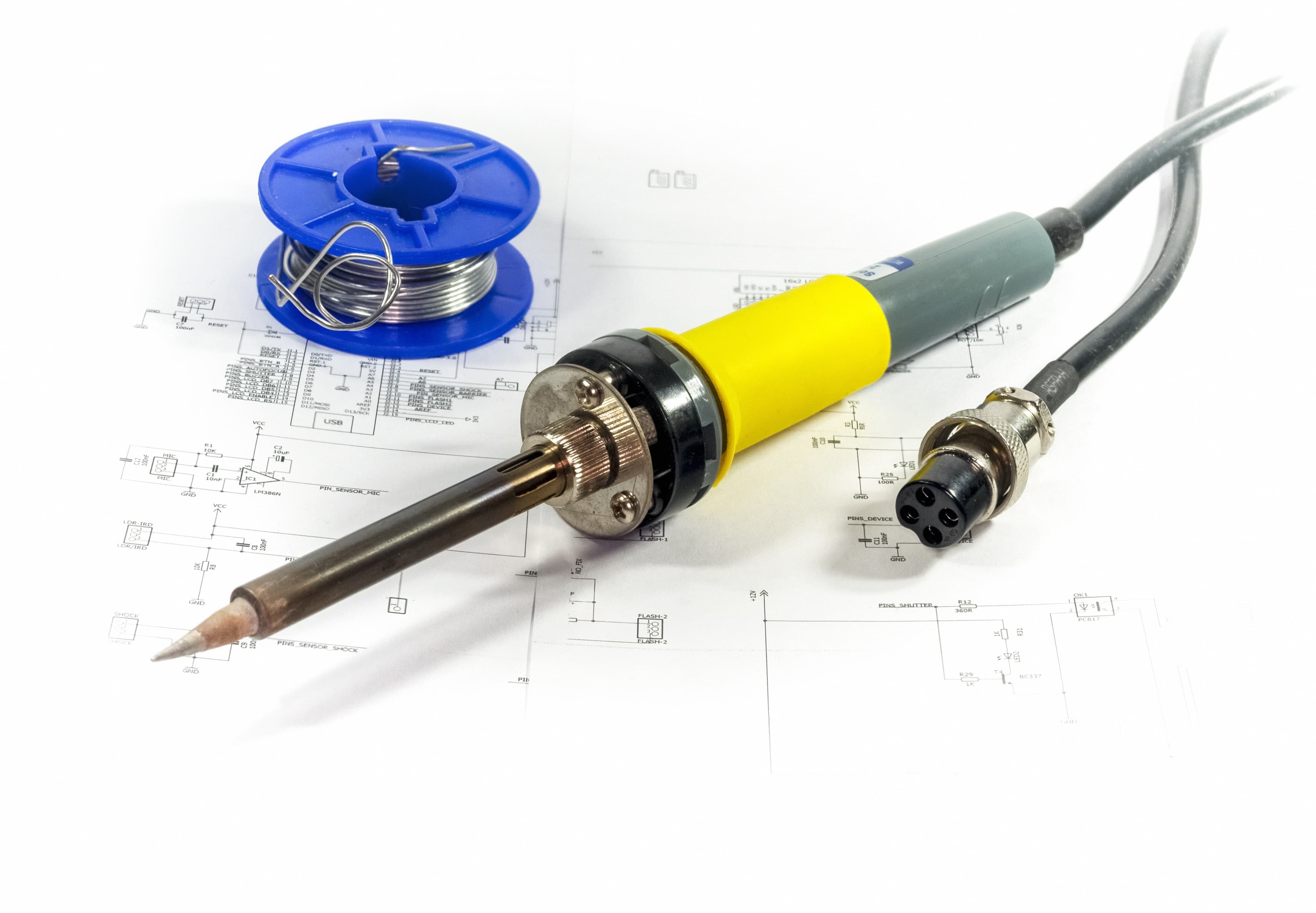 Soldering equipment and electronic schematics arranged on a work surface.